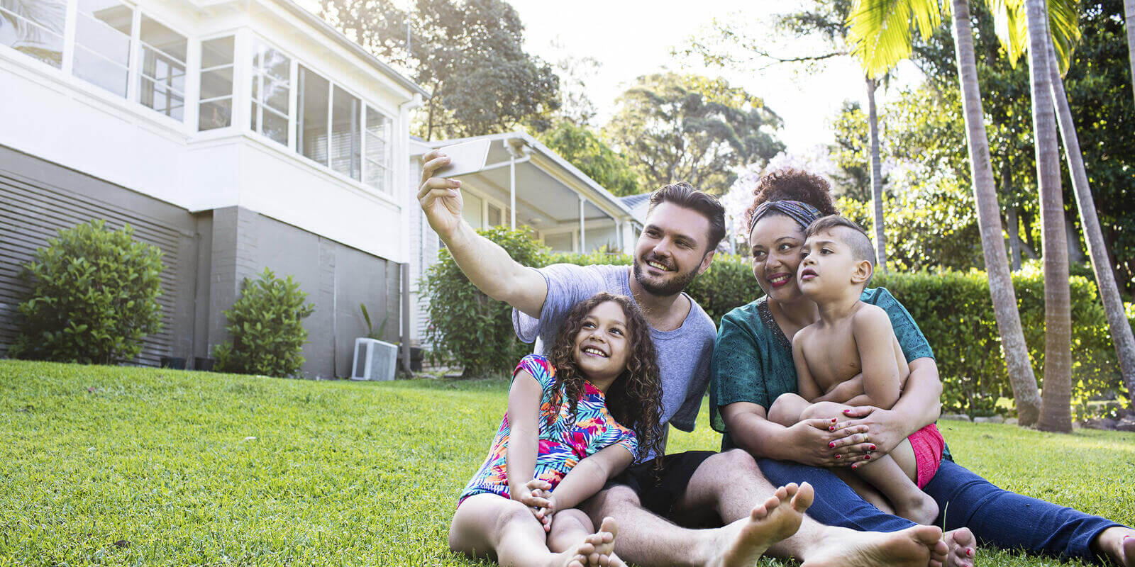 Family take selfie outside their new dream house 