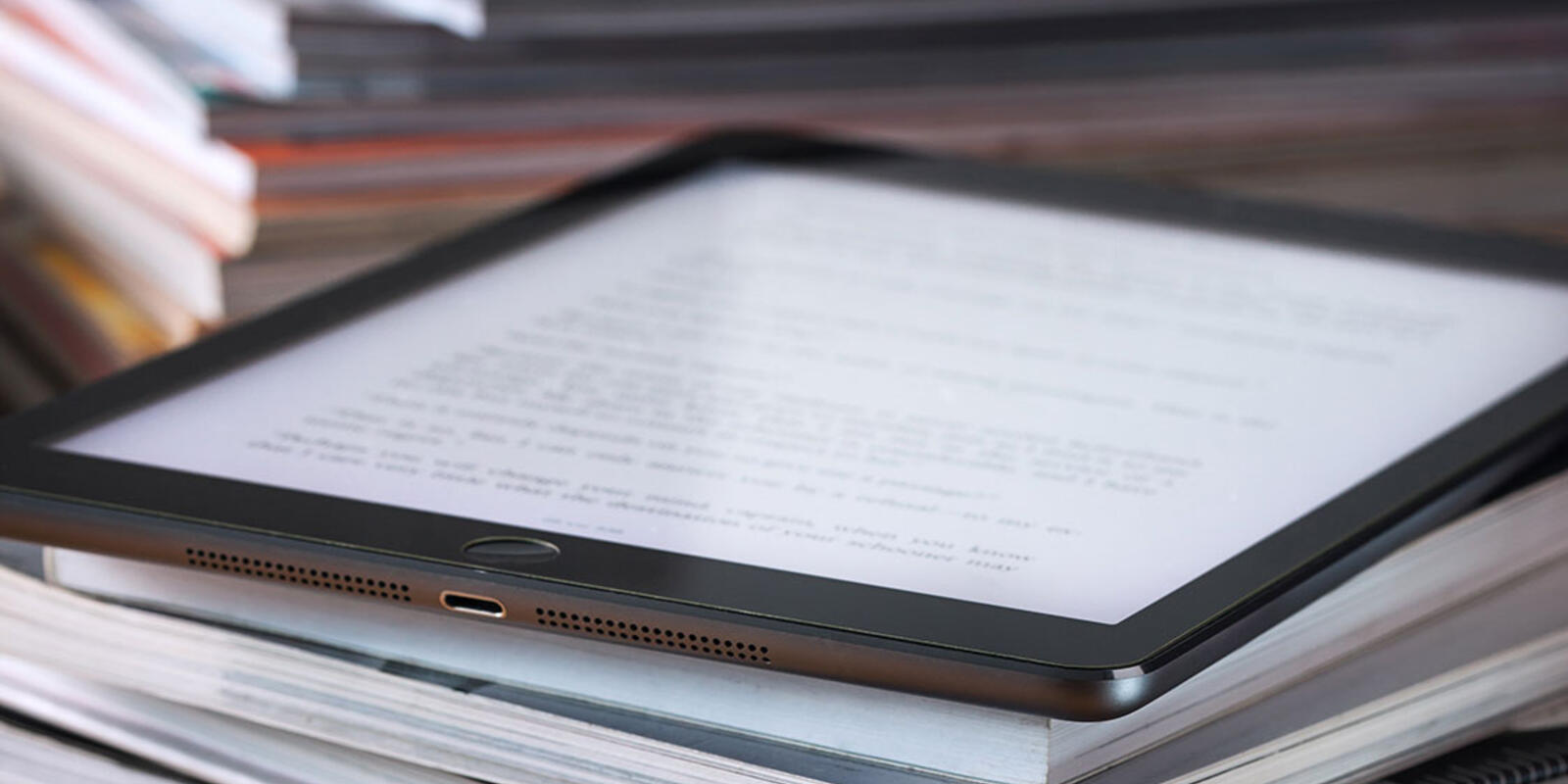 Tablet on pile of books with glasses